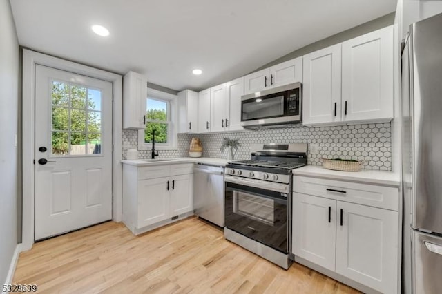 kitchen featuring backsplash, white cabinetry, sink, and stainless steel appliances