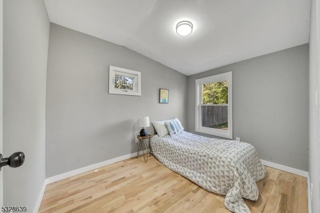 bedroom featuring vaulted ceiling and hardwood / wood-style flooring