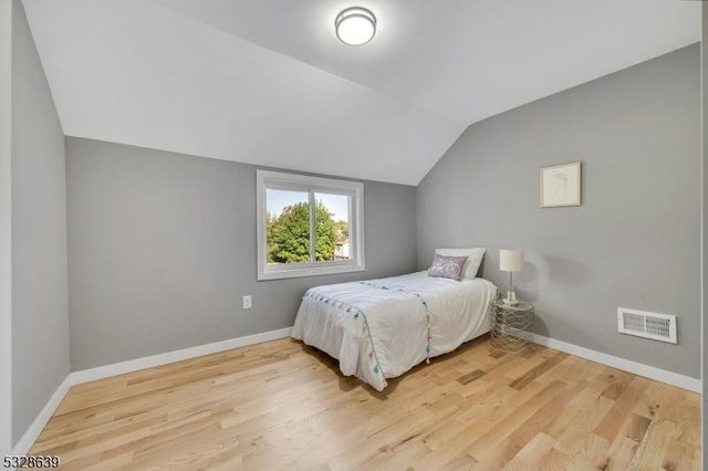 bedroom featuring hardwood / wood-style floors and lofted ceiling