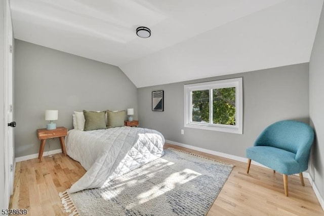 bedroom with hardwood / wood-style flooring and lofted ceiling