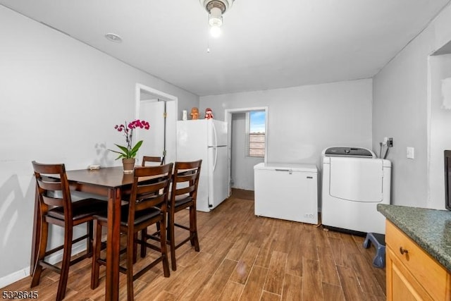 dining space featuring washer / dryer and wood-type flooring