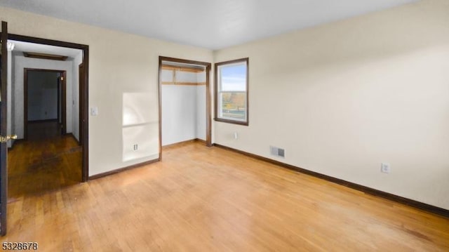 unfurnished bedroom featuring a closet and hardwood / wood-style flooring