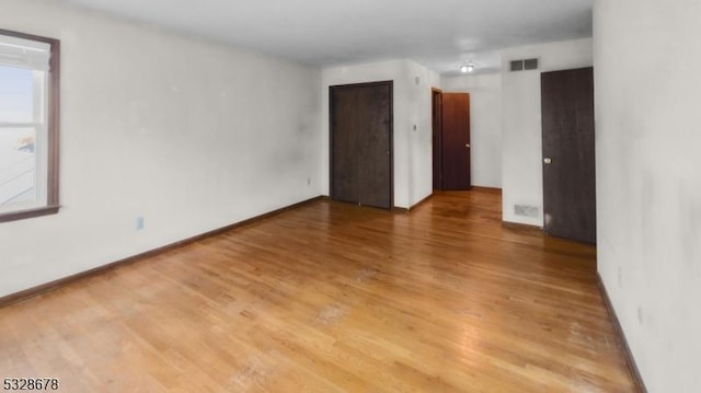 unfurnished room featuring hardwood / wood-style flooring