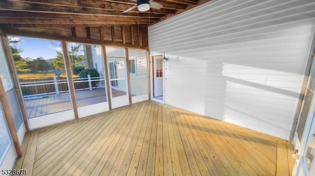 unfurnished sunroom featuring ceiling fan