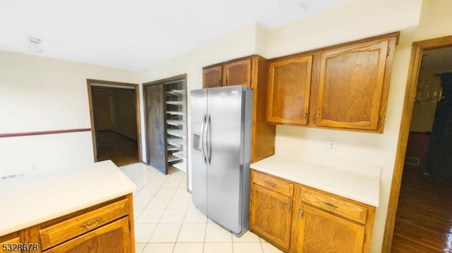 kitchen with stainless steel refrigerator with ice dispenser and light tile patterned floors