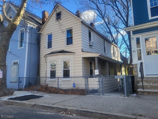 view of property exterior with a fenced front yard and a gate