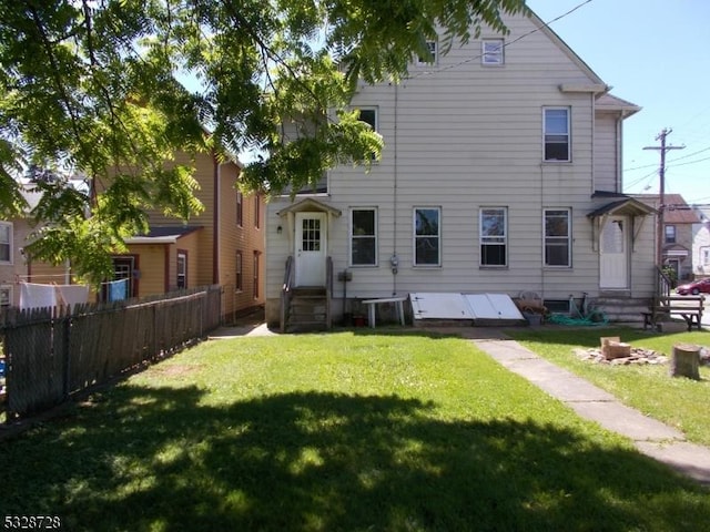 rear view of property featuring a lawn