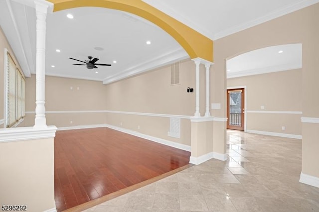 unfurnished living room featuring light hardwood / wood-style floors, ceiling fan, crown molding, and decorative columns