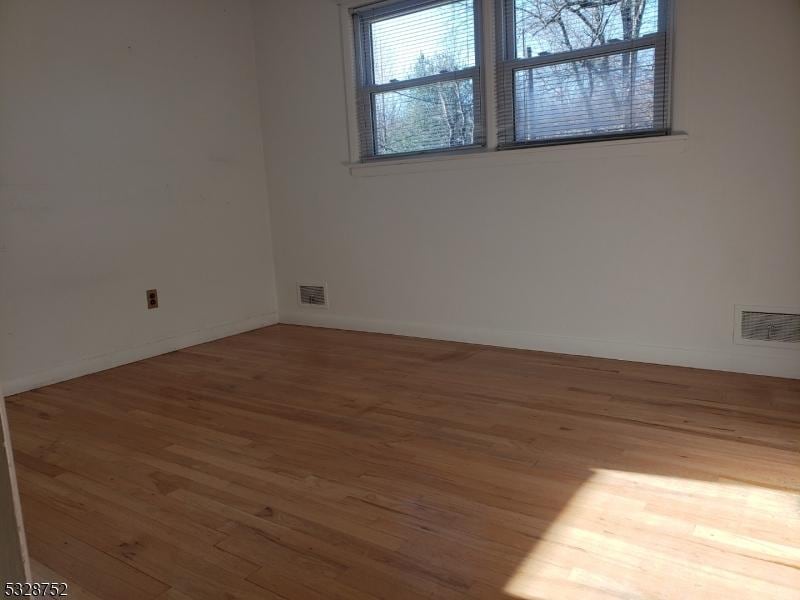 spare room with hardwood / wood-style flooring