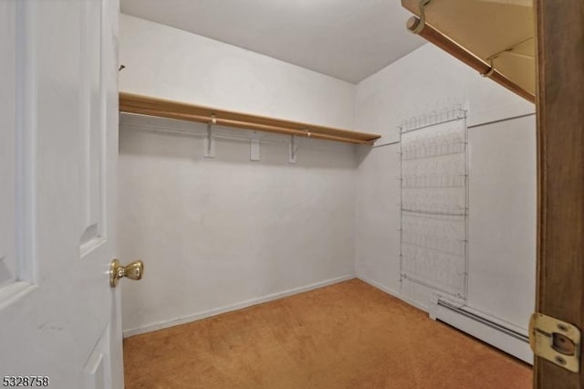 walk in closet with light colored carpet and a baseboard heating unit