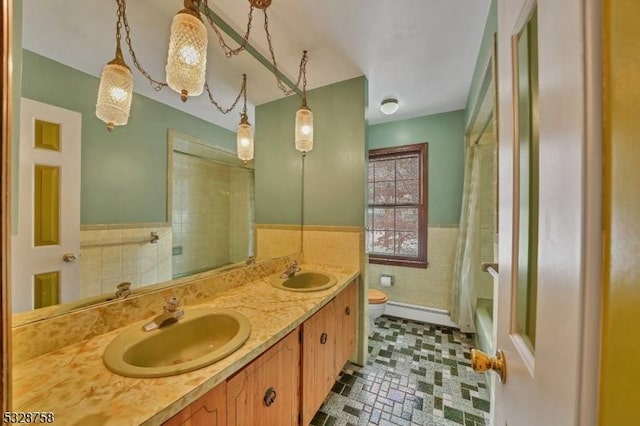 bathroom with vanity, toilet, tile walls, and walk in shower