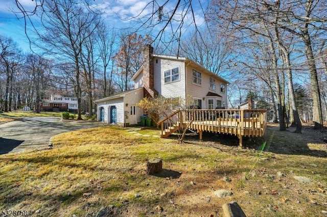 back of house featuring a deck and a garage