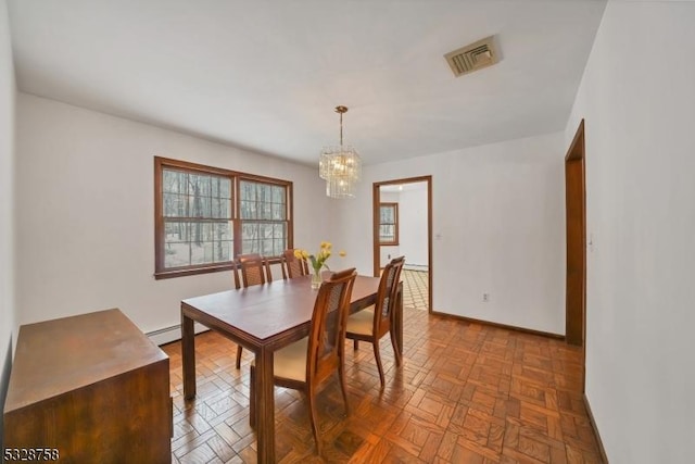 dining space featuring parquet floors, a baseboard radiator, and an inviting chandelier