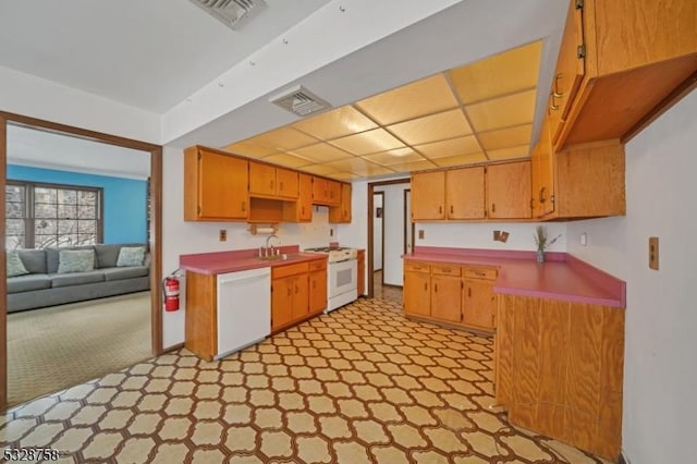 kitchen with light carpet, white appliances, and sink