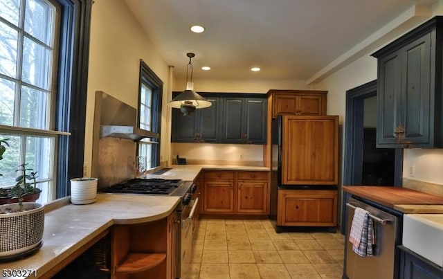 kitchen with pendant lighting, a healthy amount of sunlight, and appliances with stainless steel finishes