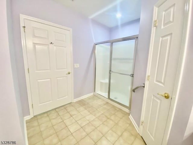 bathroom featuring tile patterned floors and a shower with shower door