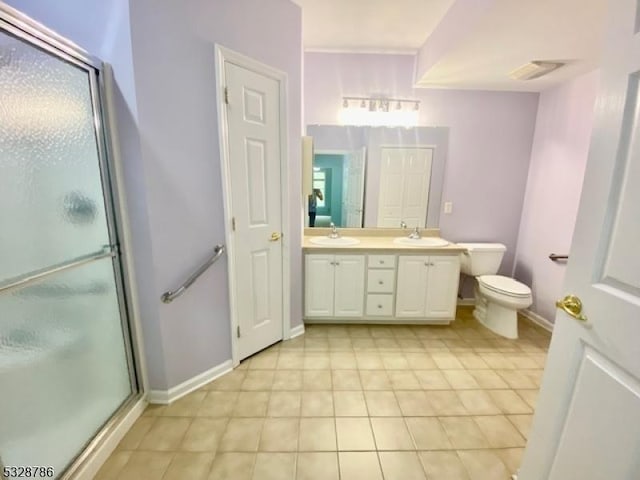 bathroom featuring tile patterned floors, vanity, toilet, and an enclosed shower