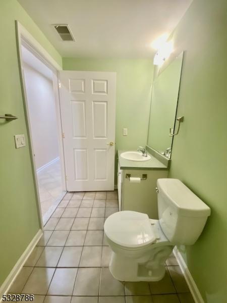 bathroom featuring tile patterned flooring, vanity, and toilet