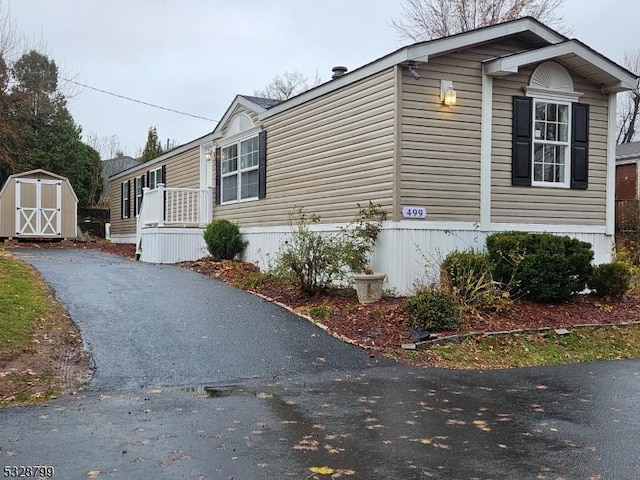 view of property exterior with a storage unit