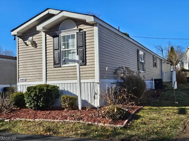 view of home's exterior featuring a lawn and central AC