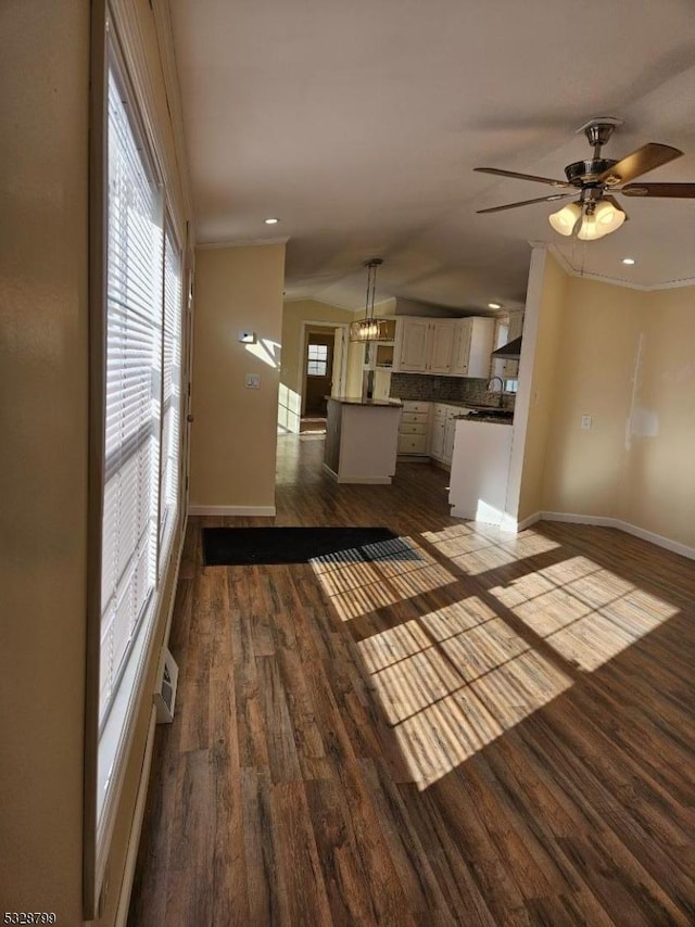 unfurnished living room featuring ceiling fan with notable chandelier and dark hardwood / wood-style floors