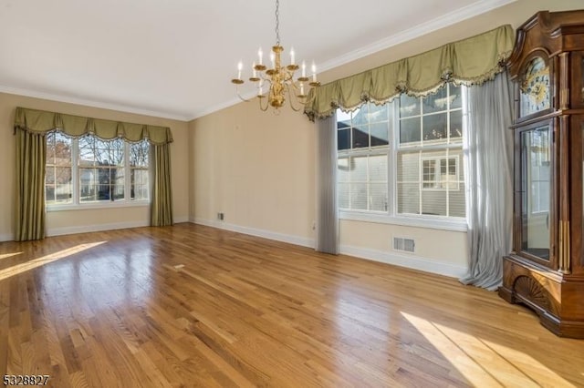 unfurnished dining area featuring a chandelier, light hardwood / wood-style flooring, and crown molding