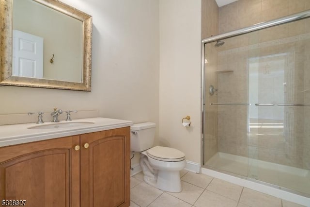 bathroom with tile patterned flooring, vanity, toilet, and a shower with door