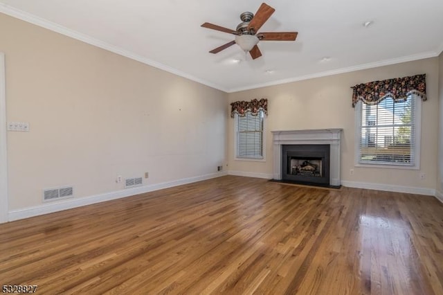 unfurnished living room featuring ceiling fan, wood-type flooring, and ornamental molding