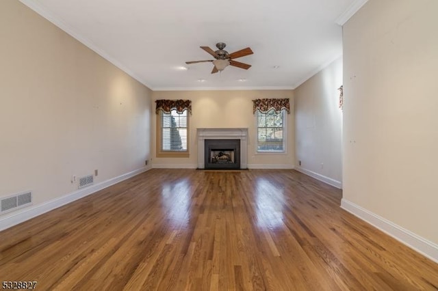 unfurnished living room featuring hardwood / wood-style floors, ceiling fan, and crown molding