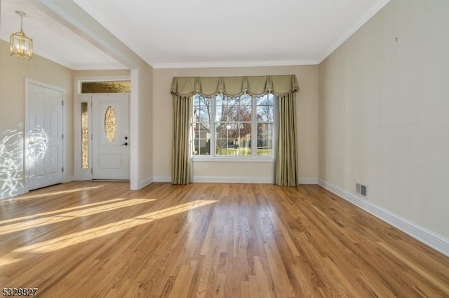 interior space with hardwood / wood-style floors, ornamental molding, and an inviting chandelier