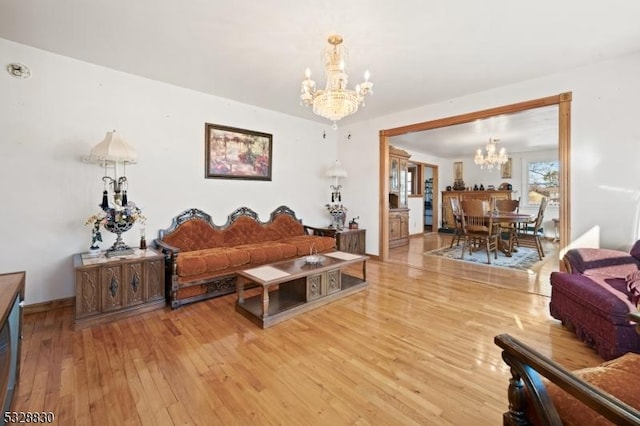 living room featuring a notable chandelier and light hardwood / wood-style floors