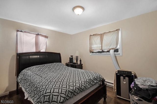 bedroom with a baseboard radiator and dark hardwood / wood-style floors