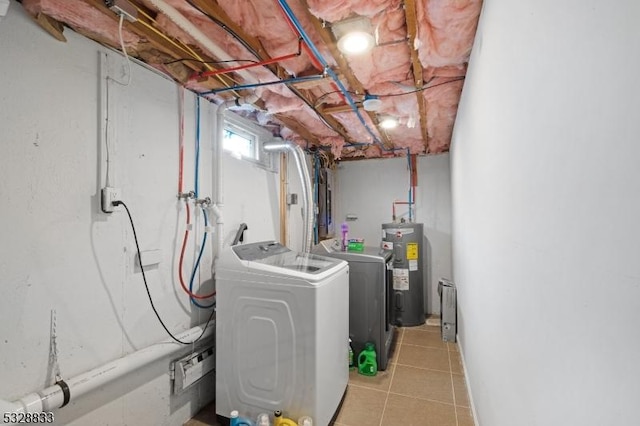 laundry area with water heater, washer and clothes dryer, and light tile patterned floors