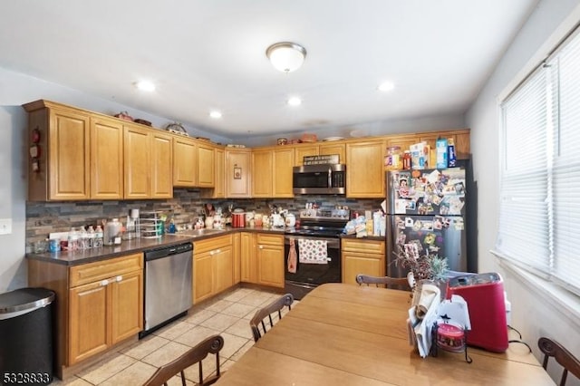 kitchen featuring tasteful backsplash, sink, light tile patterned floors, and appliances with stainless steel finishes