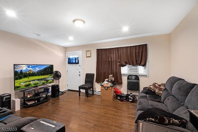 living room with cooling unit, dark wood-type flooring, and a baseboard heating unit