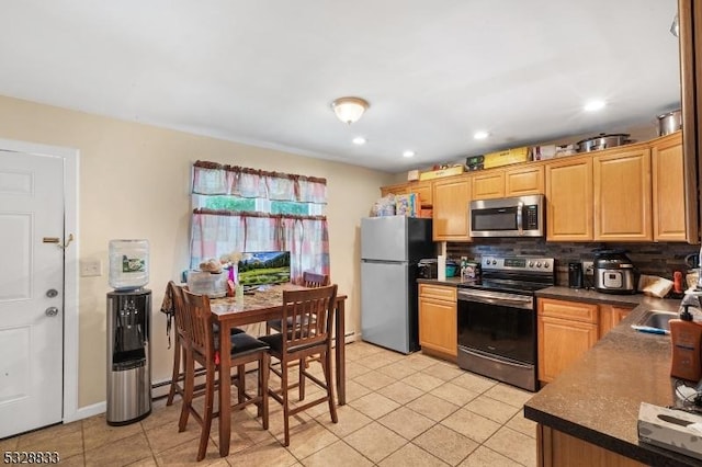 kitchen with light tile patterned flooring, sink, stainless steel appliances, and tasteful backsplash