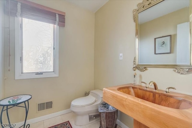 bathroom featuring toilet, tile patterned floors, and sink