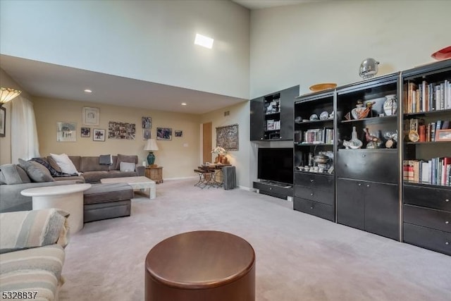 living room with a high ceiling and carpet