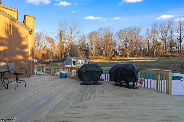 wooden terrace with a grill and an outbuilding