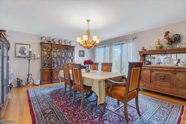 dining area featuring an inviting chandelier and light hardwood / wood-style flooring