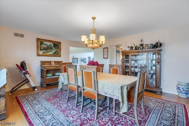 dining area with a notable chandelier and hardwood / wood-style flooring