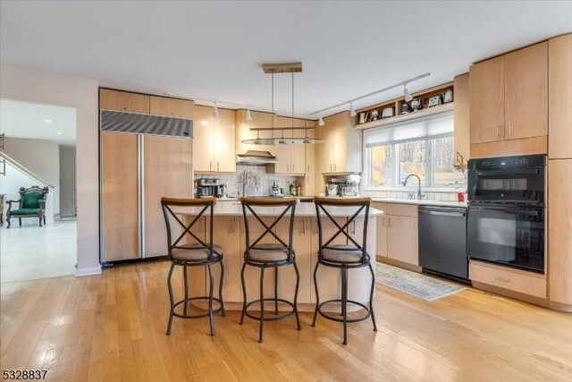 kitchen featuring backsplash, stainless steel dishwasher, hanging light fixtures, double oven, and paneled built in fridge