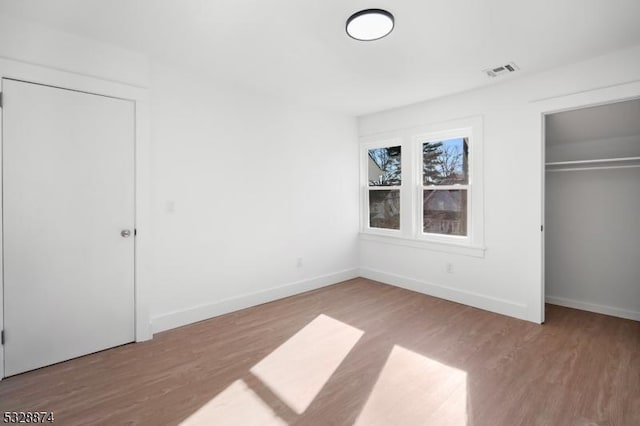 unfurnished bedroom with a closet and hardwood / wood-style flooring