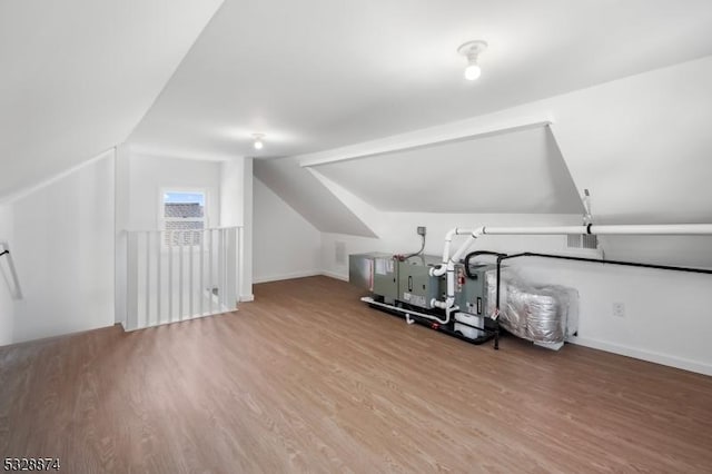 additional living space featuring hardwood / wood-style floors and vaulted ceiling