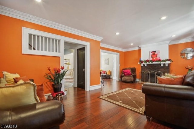 living room with a fireplace, ornamental molding, and hardwood / wood-style flooring