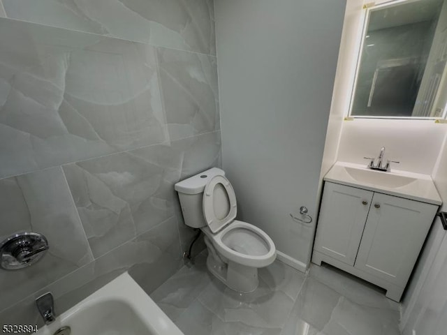 bathroom with vanity, toilet, and tile walls