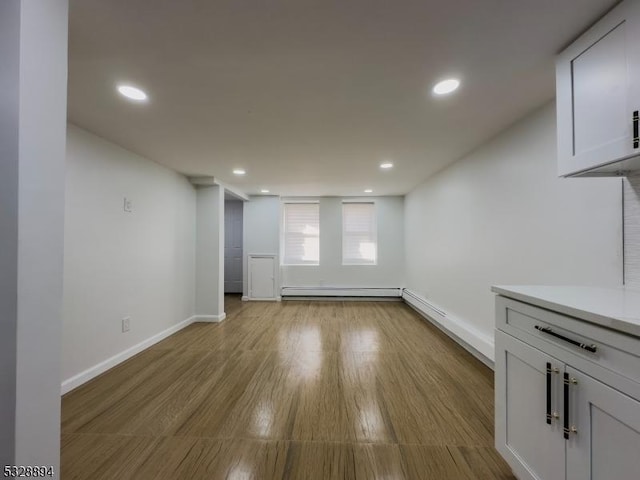 interior space featuring a baseboard radiator and light hardwood / wood-style flooring