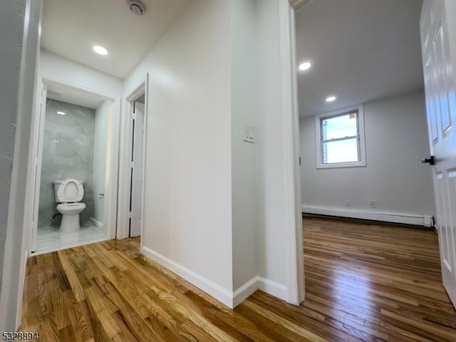 hall featuring hardwood / wood-style flooring and a baseboard heating unit