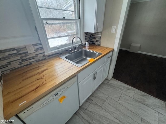 kitchen featuring backsplash, white dishwasher, sink, butcher block countertops, and white cabinetry