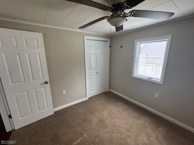 unfurnished bedroom with carpet, ceiling fan, ornamental molding, and a closet